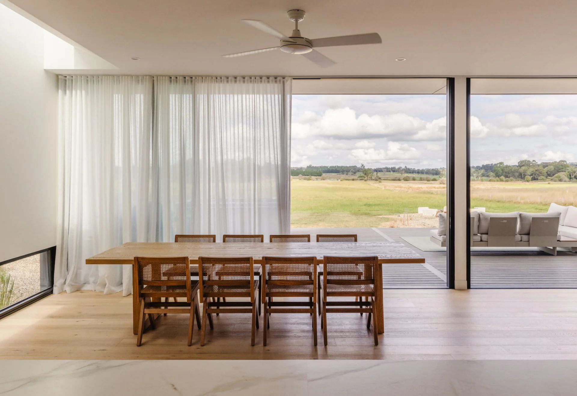Modern home interior with large aluminium windows flooding the room with natural light